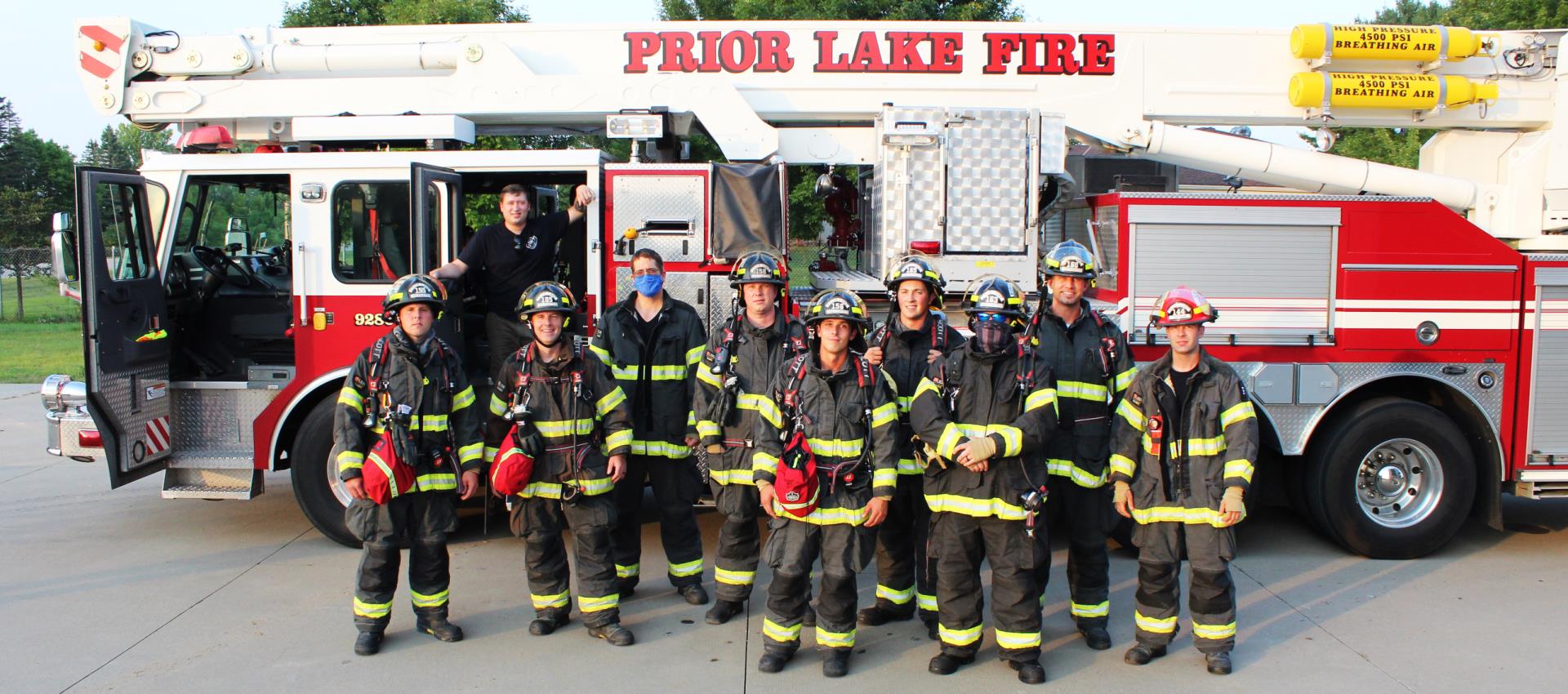 Group of firefighters standing in front of truck